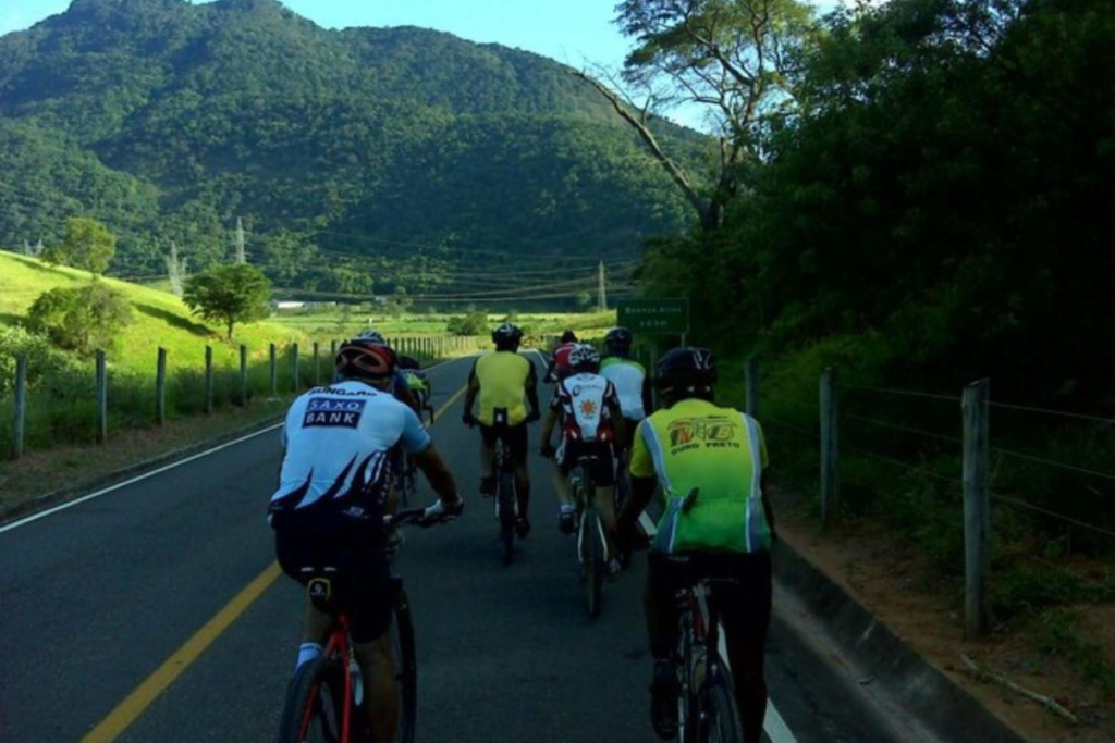 Na imagem, podemos ver sete ciclistas pedindo na Trilha do Rio do Boi, em Santa Catarina. Todos eles estão usando capacetes de segurança e roupas de ciclismo justas e vibrantes, com cores vivas e estampas chamativas.
As bicicletas que eles estão usando são variadas, desde bicicletas de montanha mais robustas até bicicletas de estrada mais leves e ágeis. Todos eles parecem estar em boa forma física, com as pernas fortes e os braços bem posicionados no guidão da bicicleta.
O clima é ensolarado e agradável, criando uma atmosfera de alegria e camaradagem. Os ciclistas estão pedalando juntos, formando um grupo coeso e animado. Eles estão aproveitando cada momento do passeio, desafiando seus limites físicos e mentais, e se conectando com a natureza ao seu redor.
A imagem transmite uma sensação de união, aventura e liberdade, mostrando que pedalar em um local amigável como a Trilha do Rio do Boi pode ser uma experiência incrível e enriquecedora para os amantes da bicicleta.